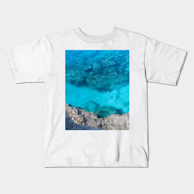 Crystal clear blue ocean water Kids T-Shirt by angiepaszko